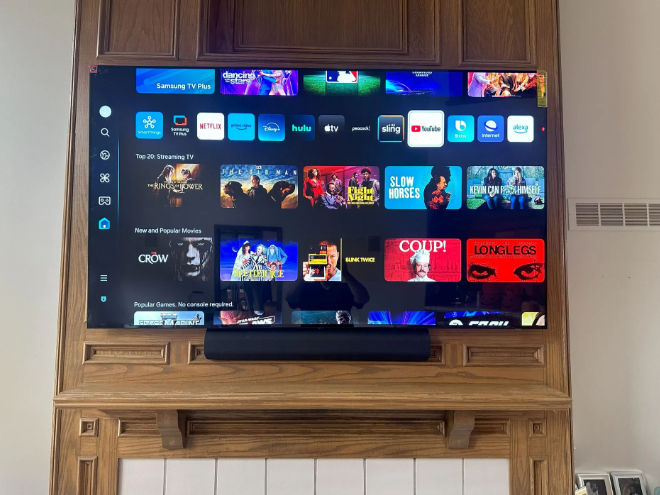 TV displaying a streaming app home screen mounted in a wooden cabinet in a living room