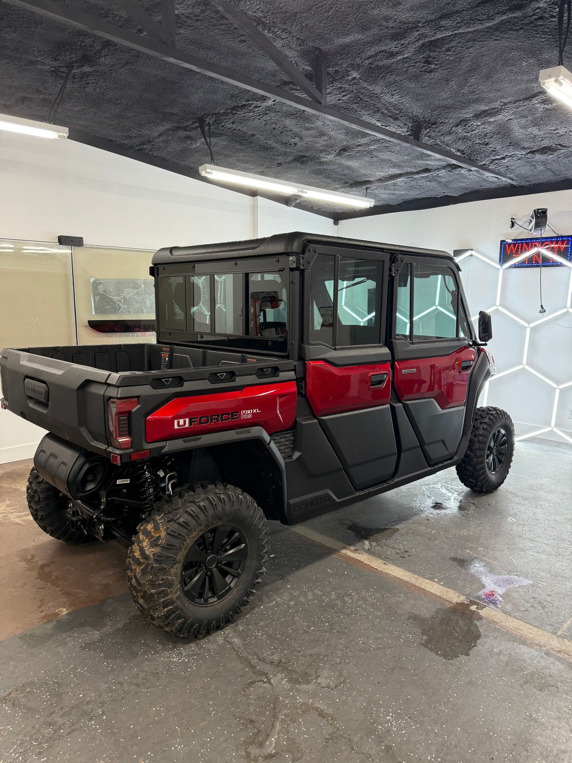White Jaguar sedan parked inside a garage, next to what seems to be a TV.