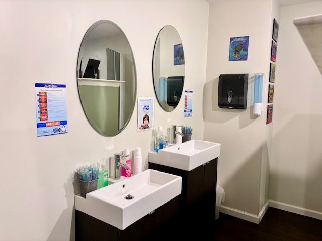 A bathroom with two sinks and two mirrors on the wall.