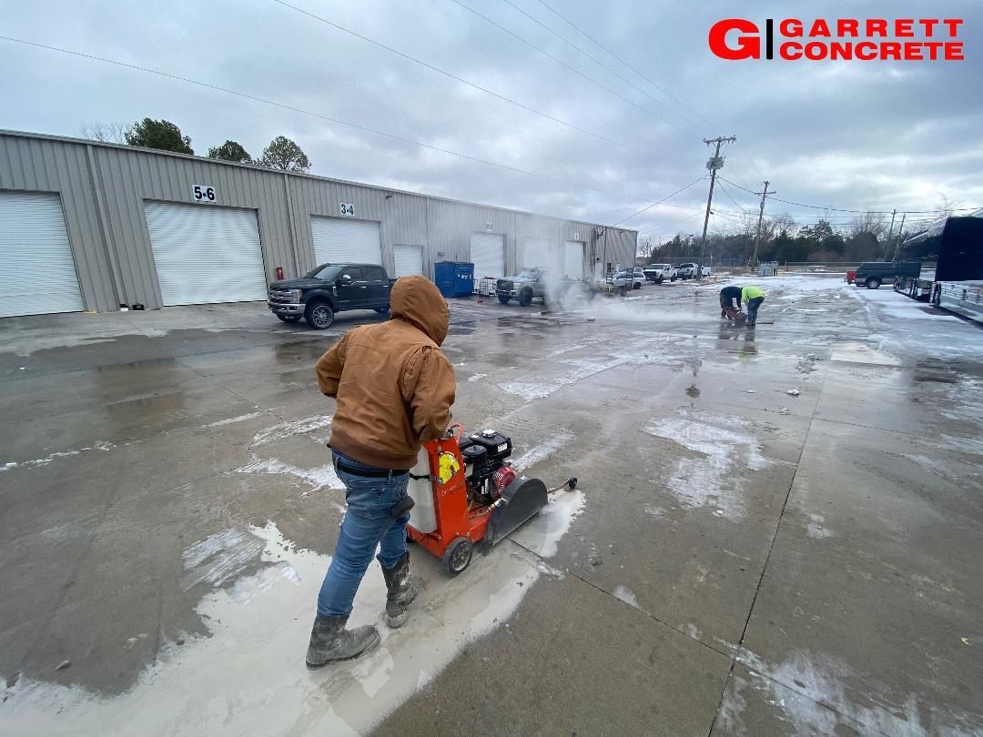 a man is using a machine to cut concrete in a parking lot