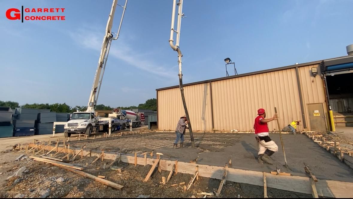 a man in a red shirt is standing in front of a concrete pump