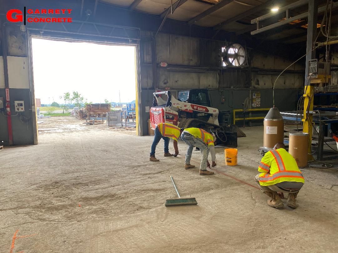 a group of construction workers are cleaning the floor of a warehouse