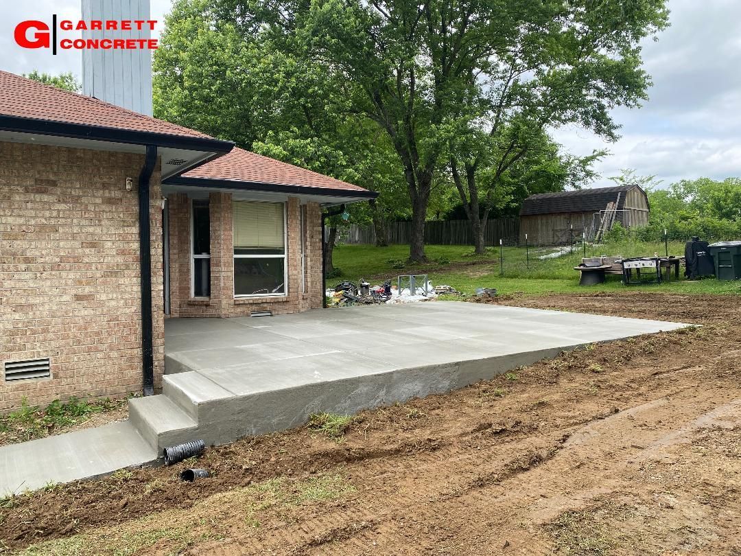 a brick house with a concrete patio in front of it