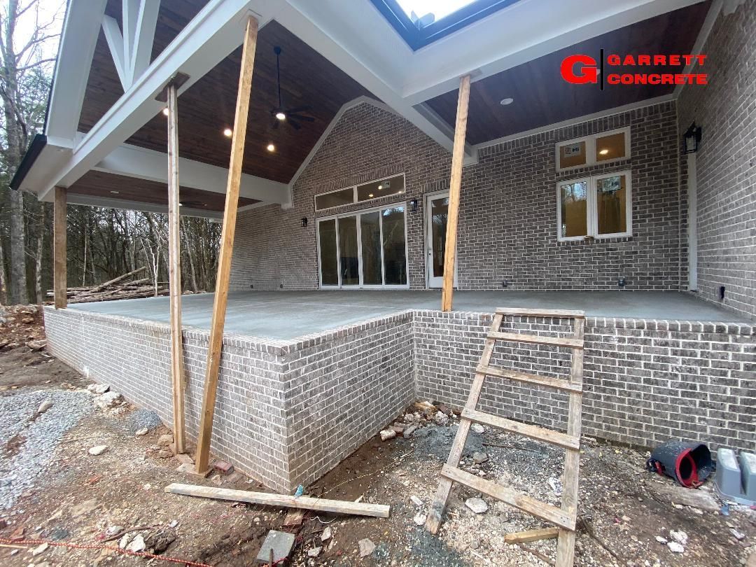 a large brick house with a covered porch under construction