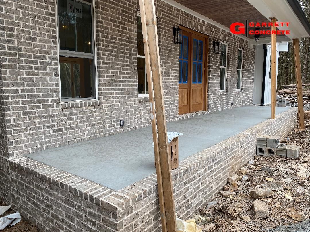 a brick house with a concrete porch in front of it