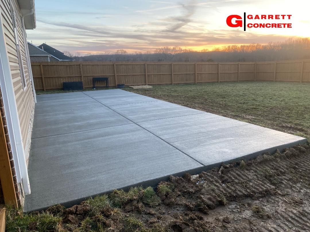 a concrete patio is being built in the backyard of a house