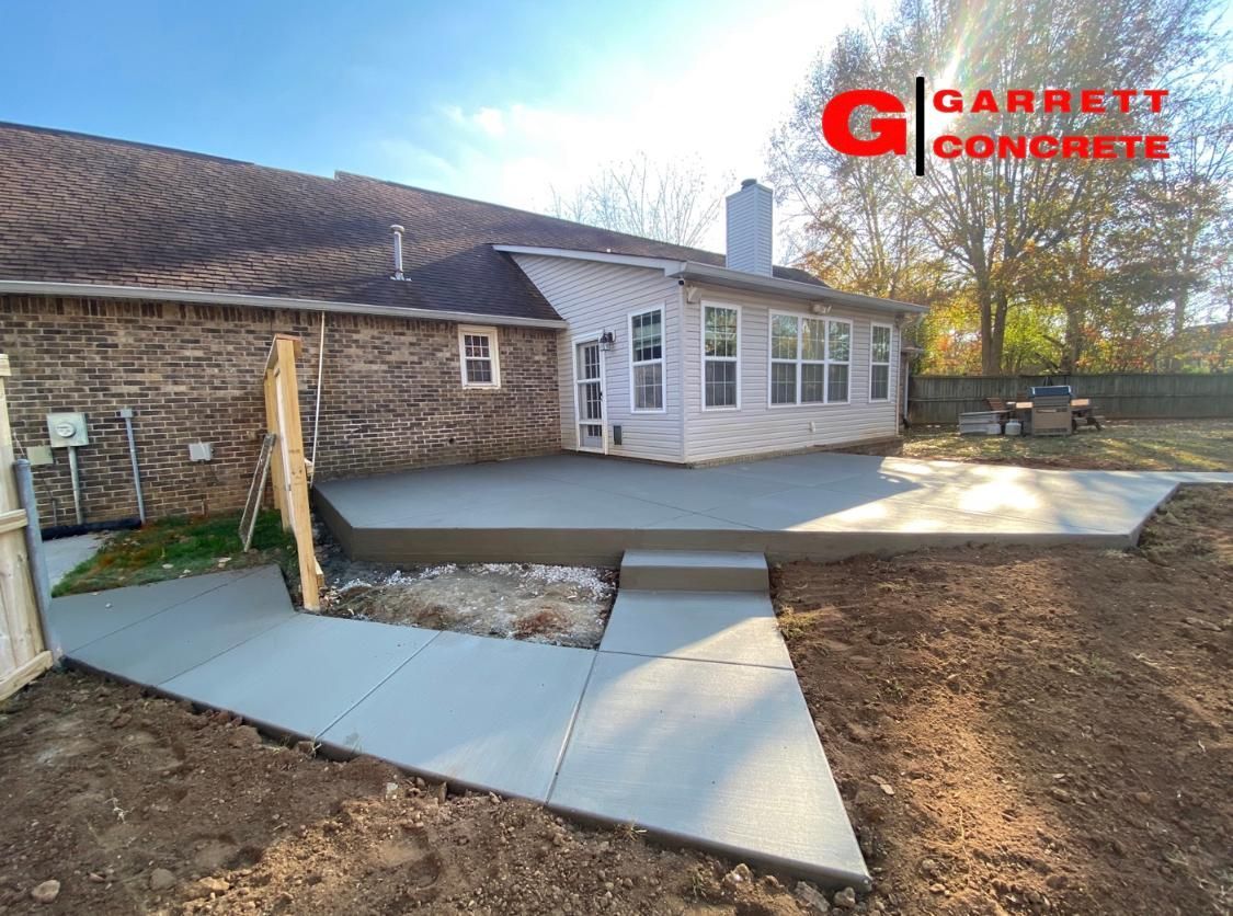 a concrete patio is being built in the backyard of a house