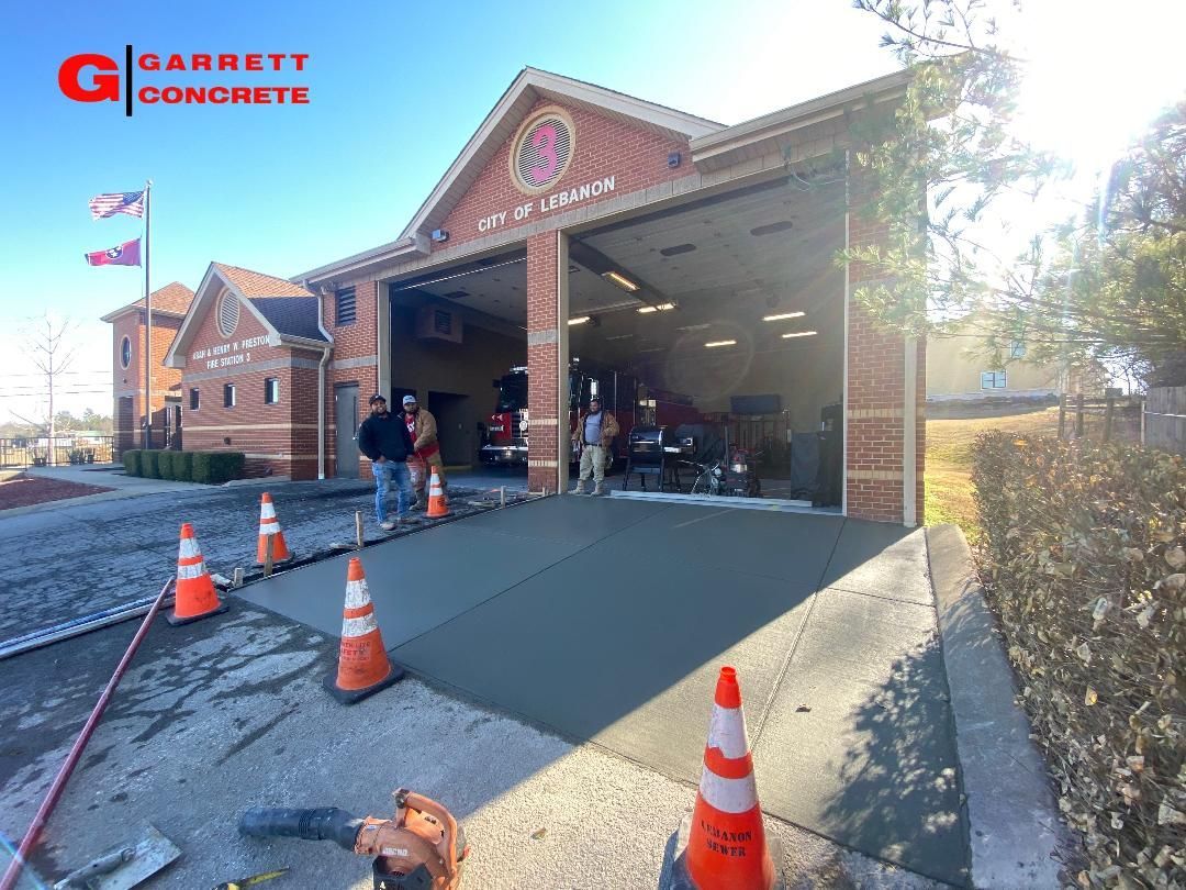 a concrete driveway is being built in front of a fire station