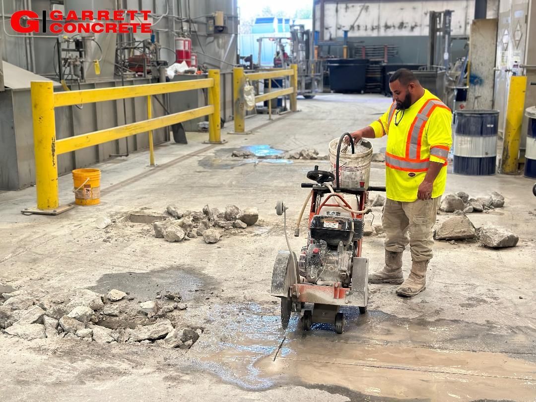 a man is using a concrete saw to cut a hole in the floor