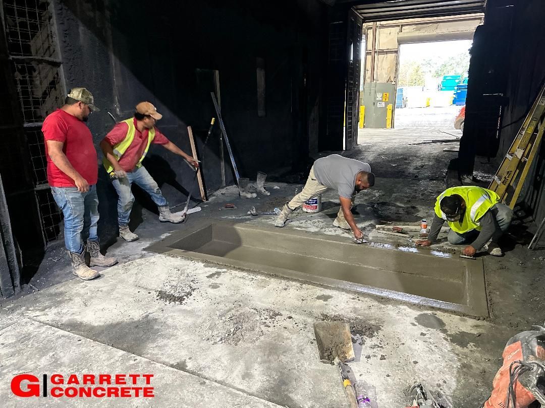 a group of construction workers are working on a concrete floor