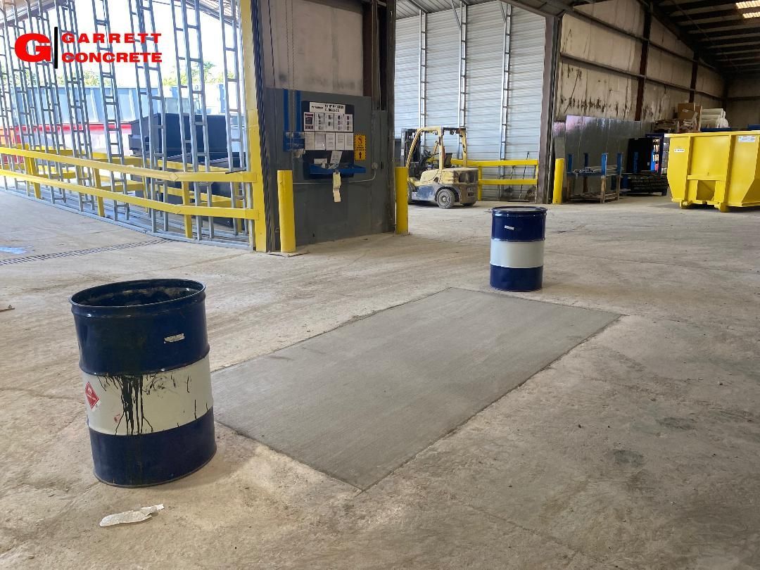 two barrels are sitting on a concrete floor in a warehouse