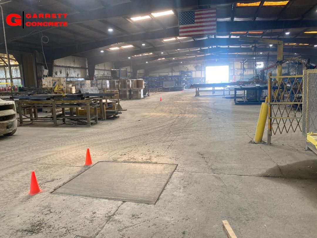 a large warehouse with a lot of machinery and cones on the floor