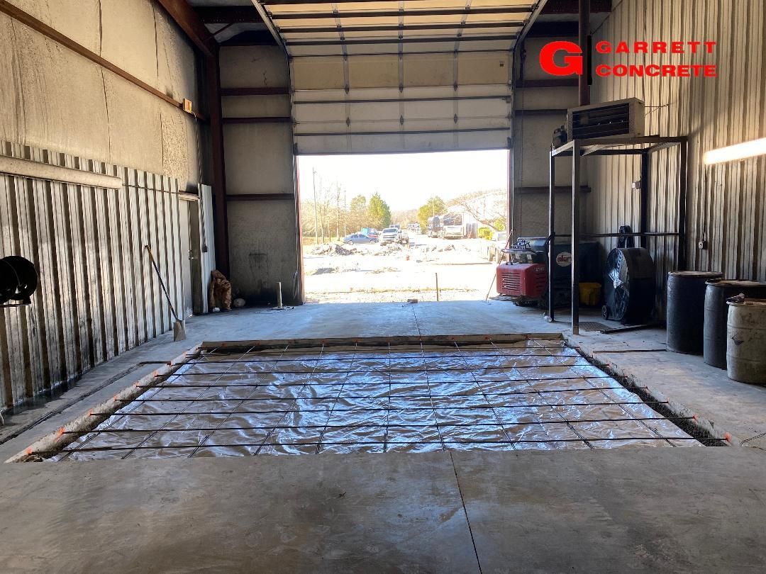 a garage with a concrete floor and a large garage door