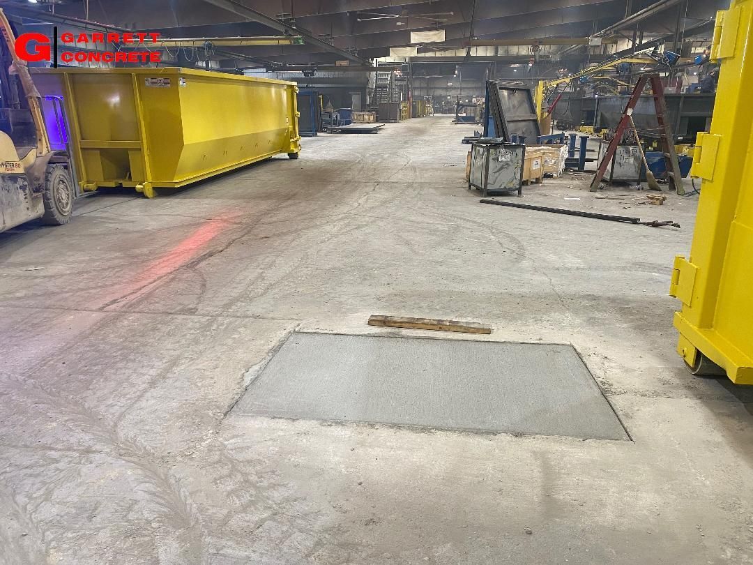 a large yellow dumpster is sitting in a large warehouse