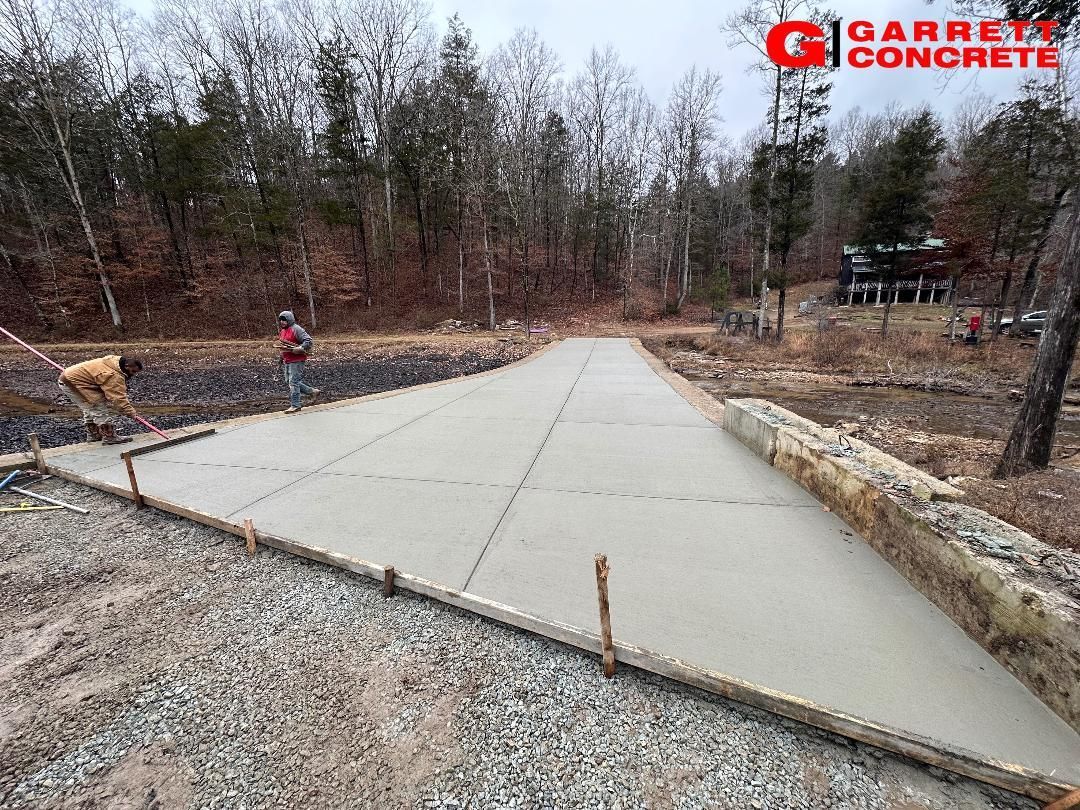 a concrete driveway is being built in the middle of a forest