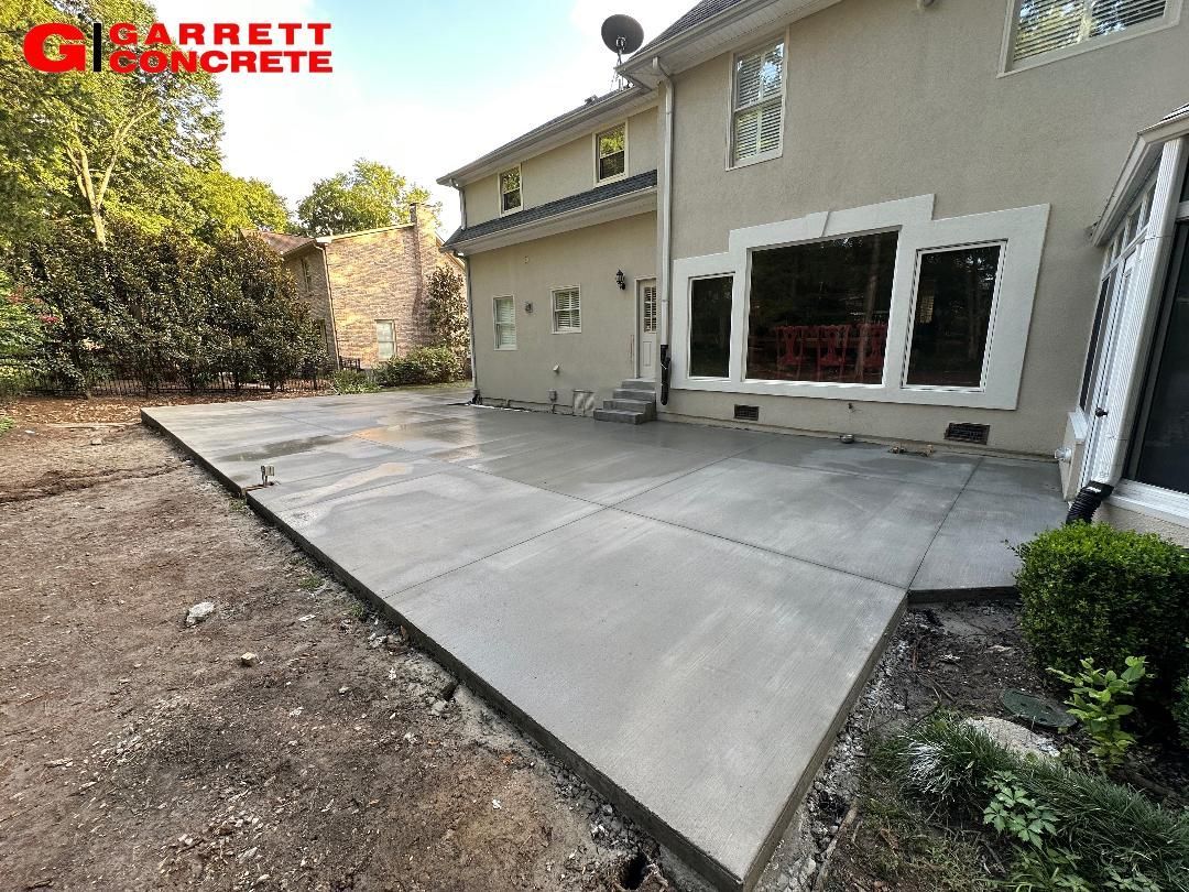 a concrete patio is being built in the backyard of a house