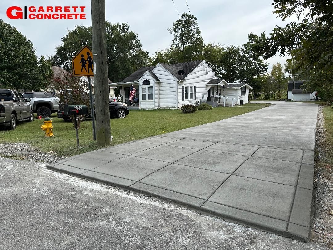 a concrete driveway with a fire hydrant on the side of it
