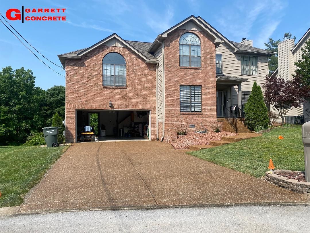 a large brick house with a concrete driveway in front of it