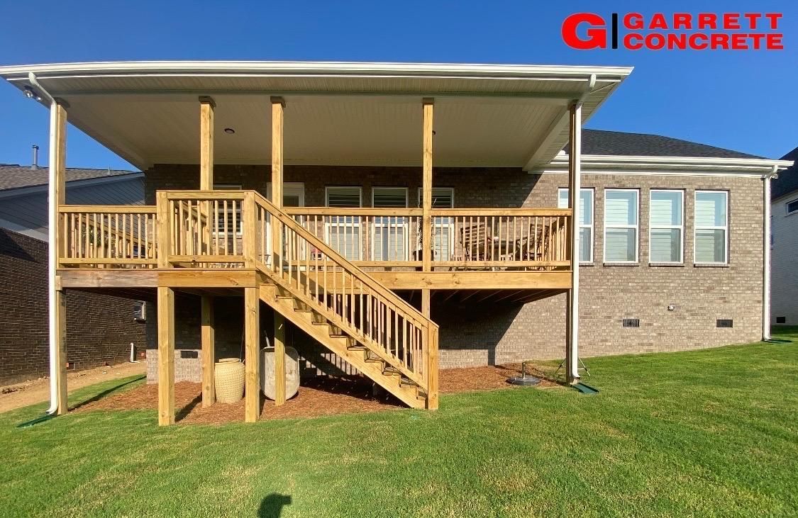 the back of a house with a wooden deck and stairs