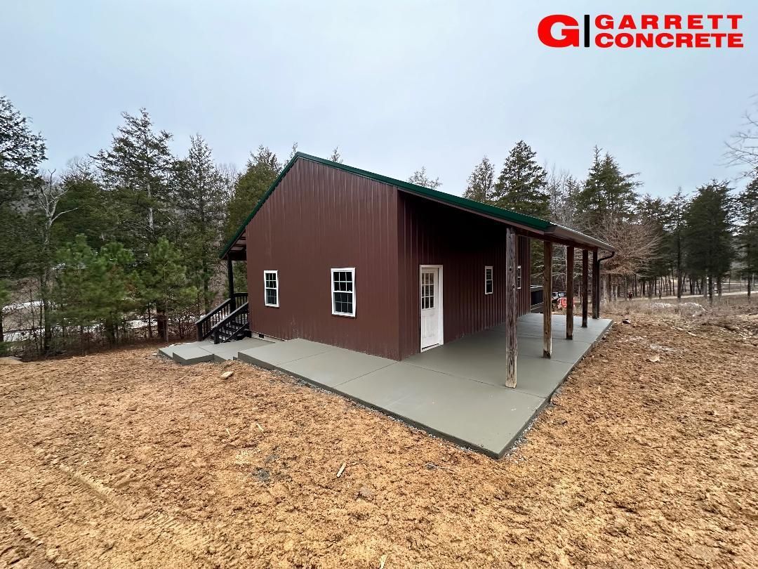 a brown building with a green roof is sitting in the middle of a field