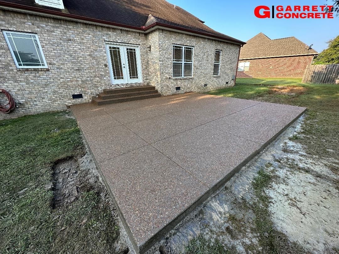 a brick house with a concrete patio in front of it