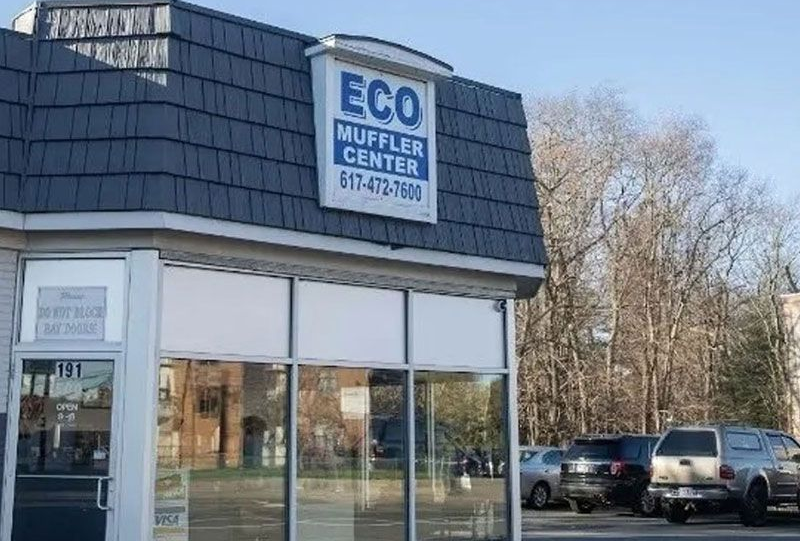 Blue Corvette on a lift in a mechanic's shop, showing undercarriage and exhaust system.