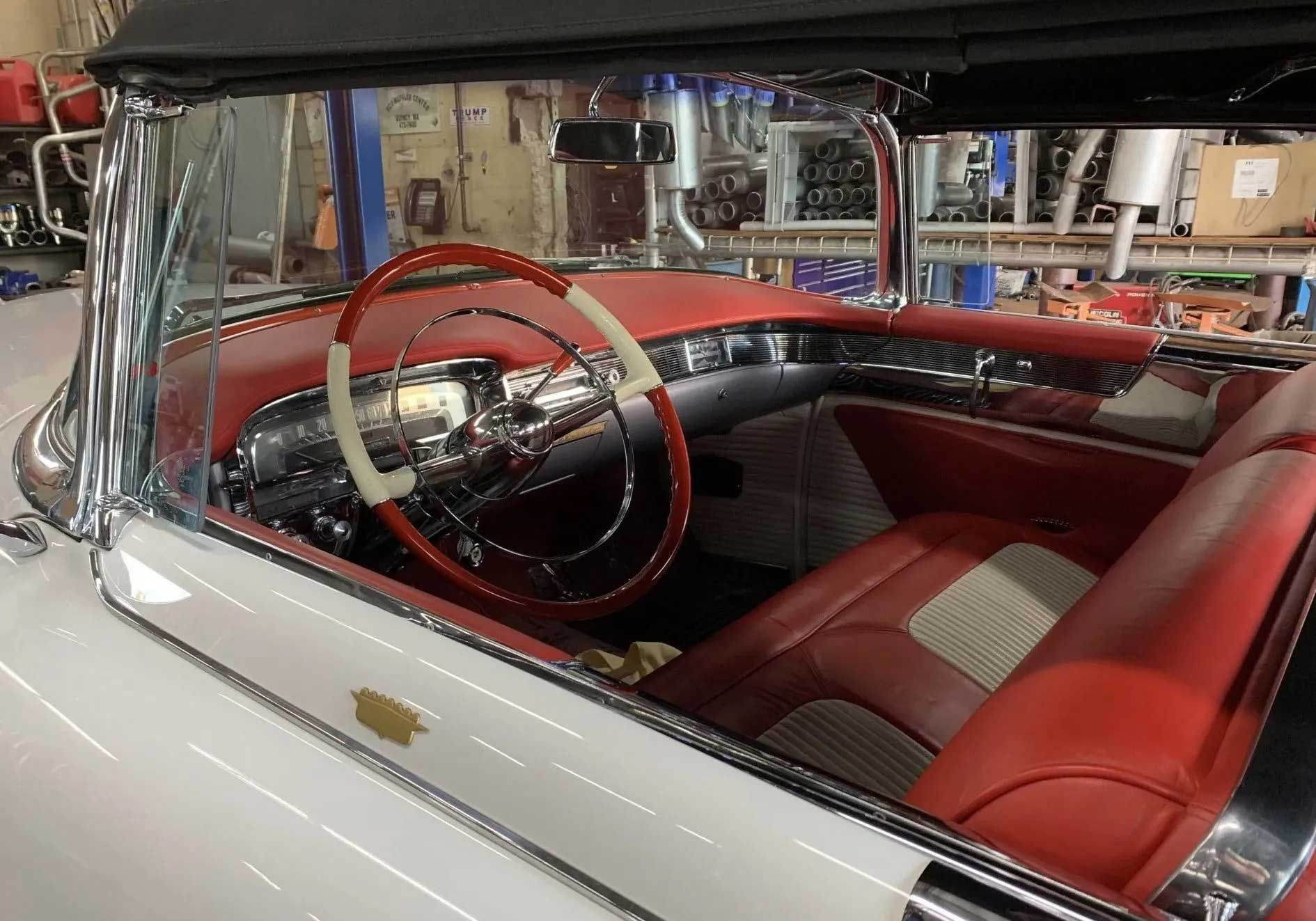 Inside a vintage white convertible car, red and white interior.