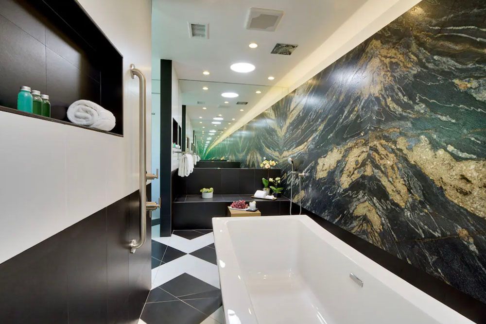 A bathroom with a bathtub and a black and white checkered floor