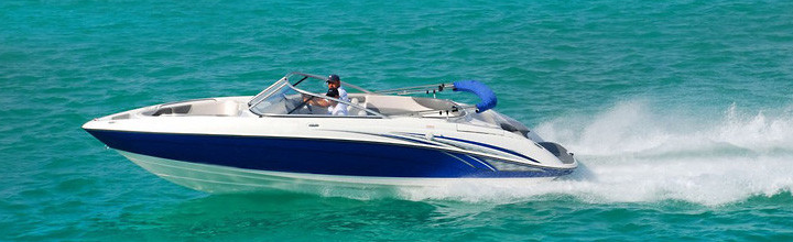 A blue and white speed boat is going through the ocean.