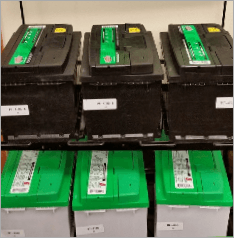 A bunch of batteries are lined up on a shelf