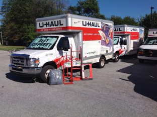 Several u-haul trucks are parked in a parking lot