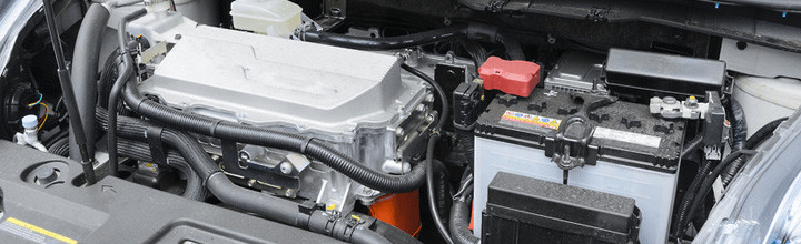 A close up of the engine of a car with the hood open.