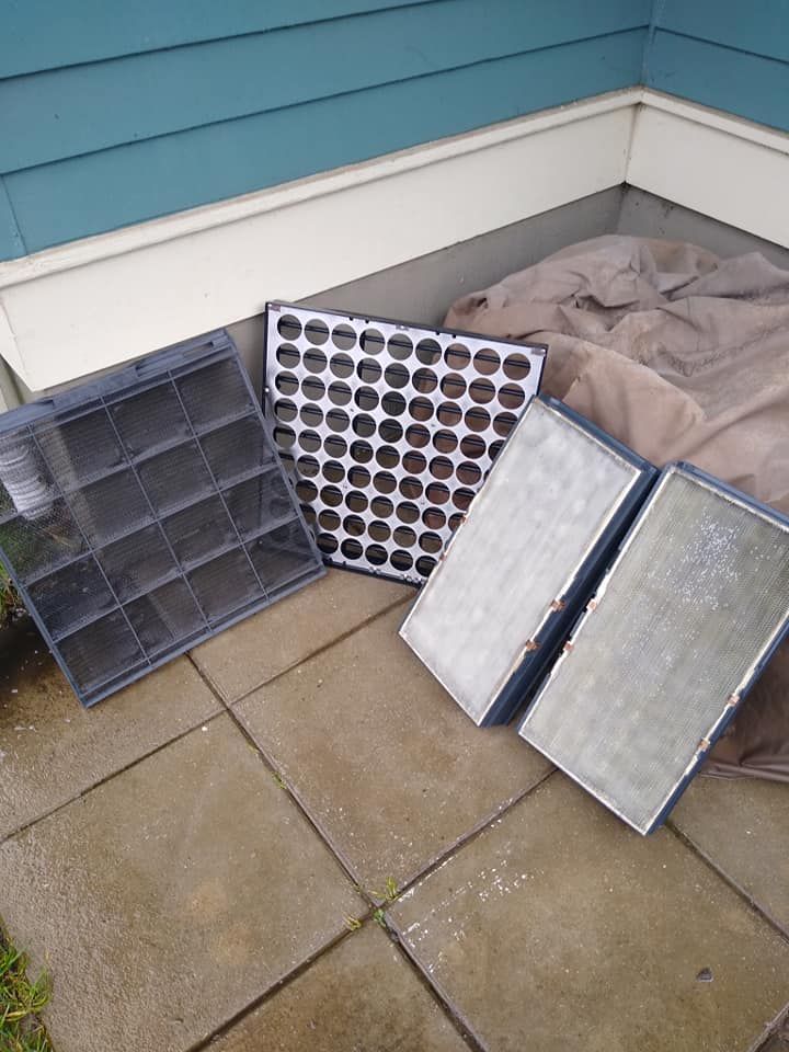 A bunch of filters are sitting on a tiled floor in front of a house.
