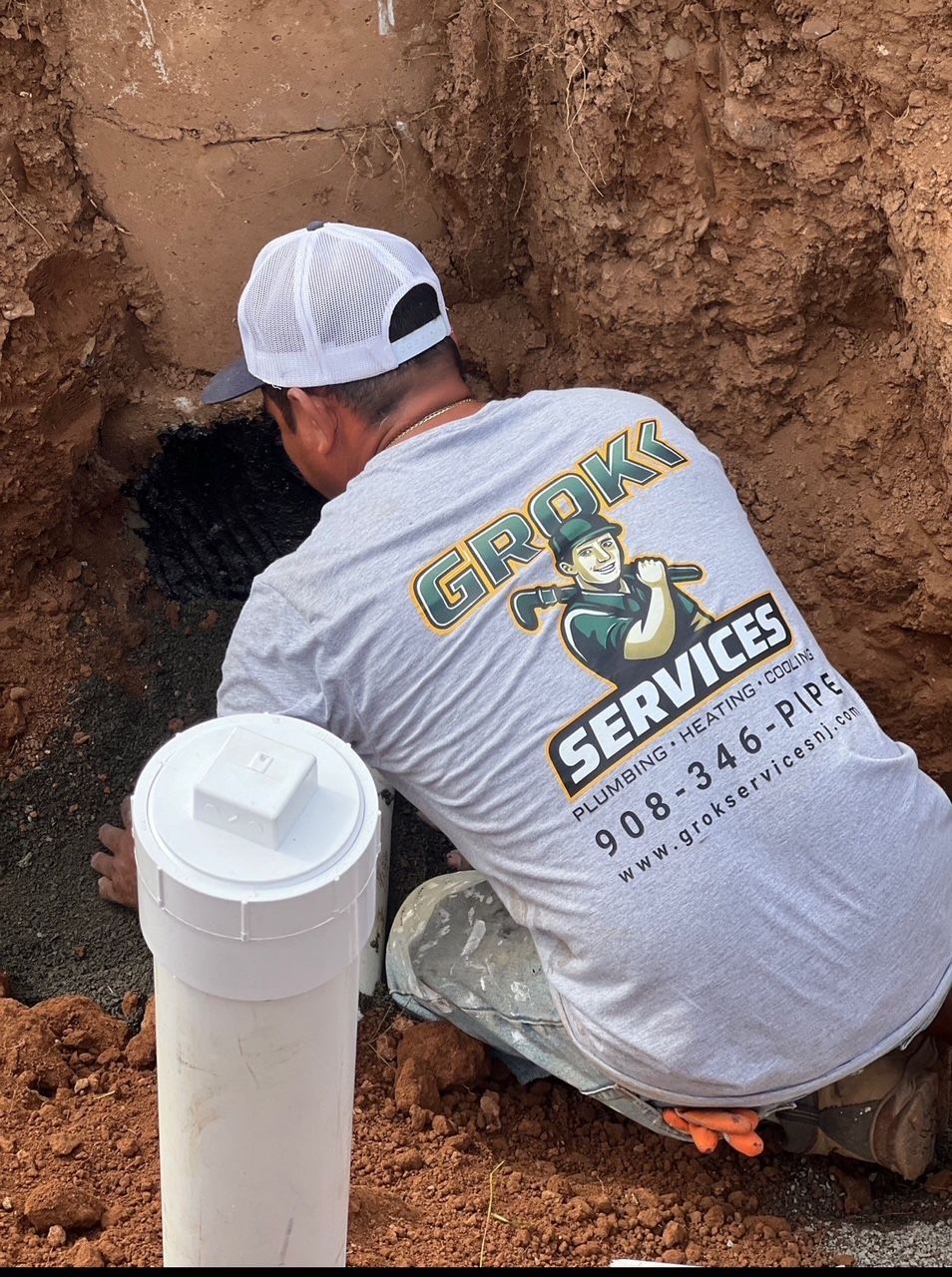 plumber installing pipe in an excavation