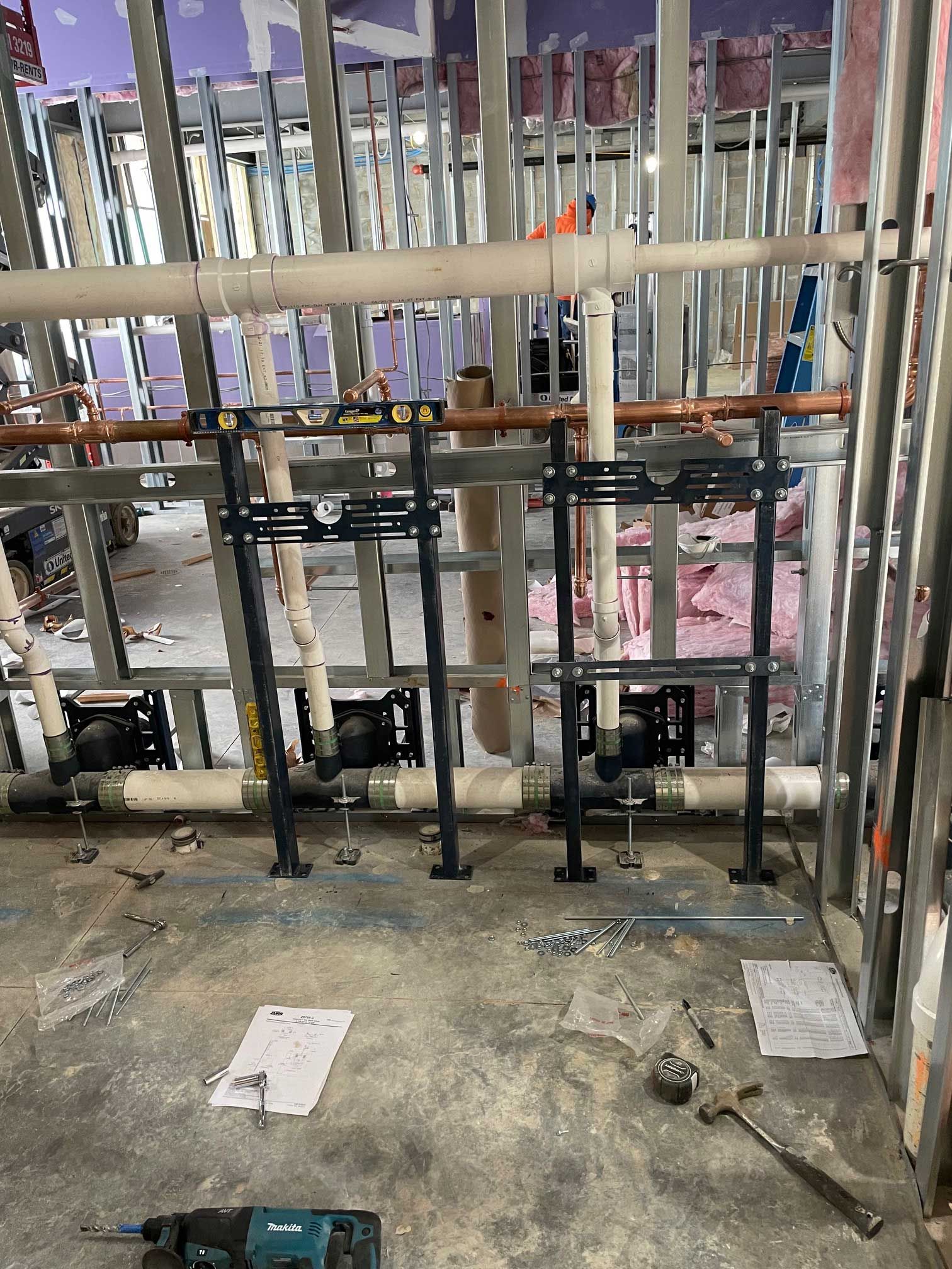 plumbing pipes and black metal supports installed in a construction site