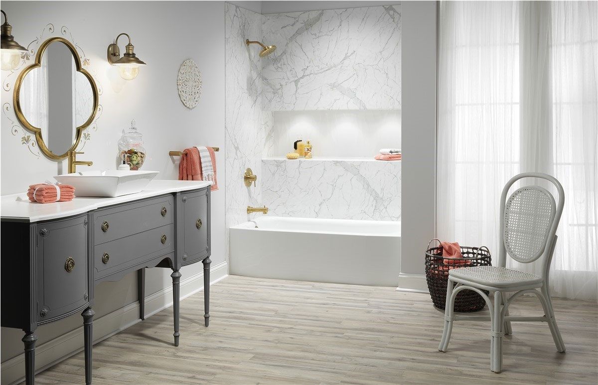 Accessible bathroom with walk-in shower, white tub, gray floor, and sink
