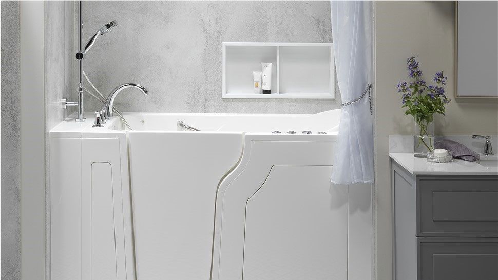 Accessible bathroom with roll-in marble shower, tub, sink, and gray floor.
