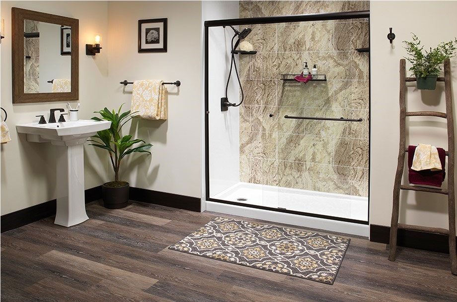 Accessible bathroom with walk-in shower, white tub, gray floor, and sink on the right