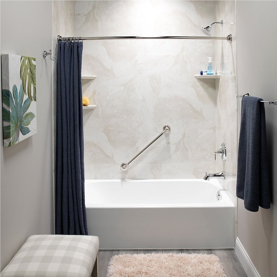 Modern bathroom with white tub, navy shower curtain, towel bars, and striped stool.