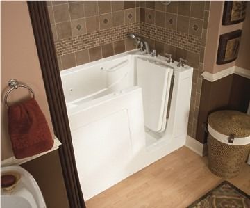 Accessible bathtub with built-in seat and handrail in a tiled bathroom