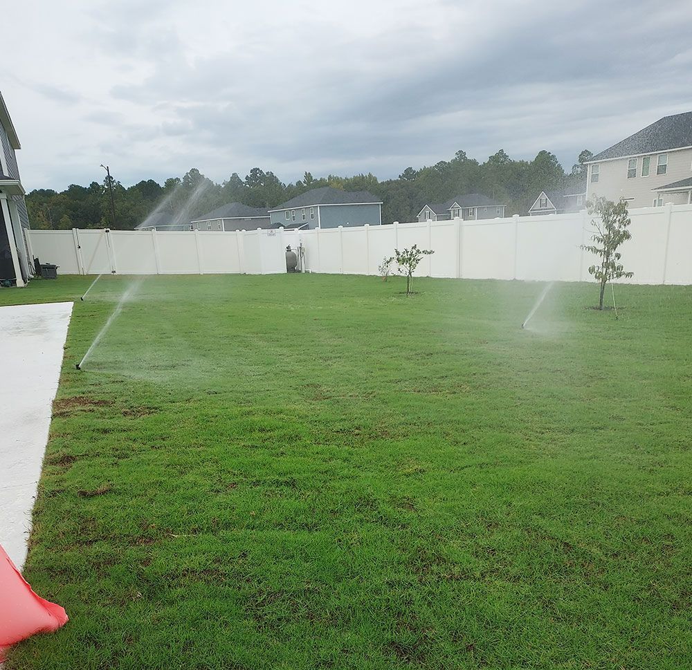 A lawn sprinkler is spraying water on a lush green lawn