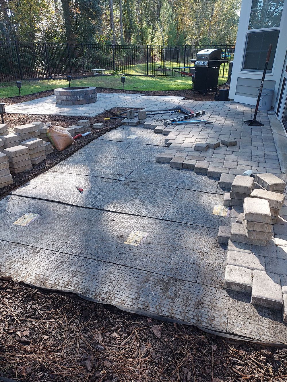 A patio is being built in a backyard.