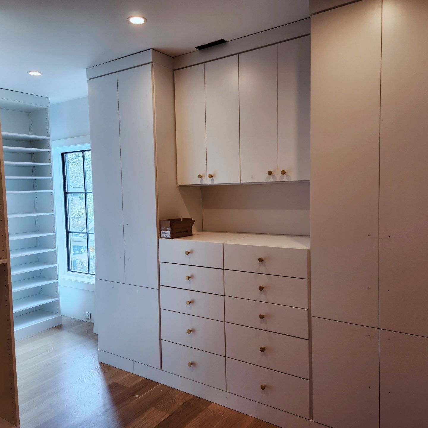 A room with lots of white cabinets and drawers