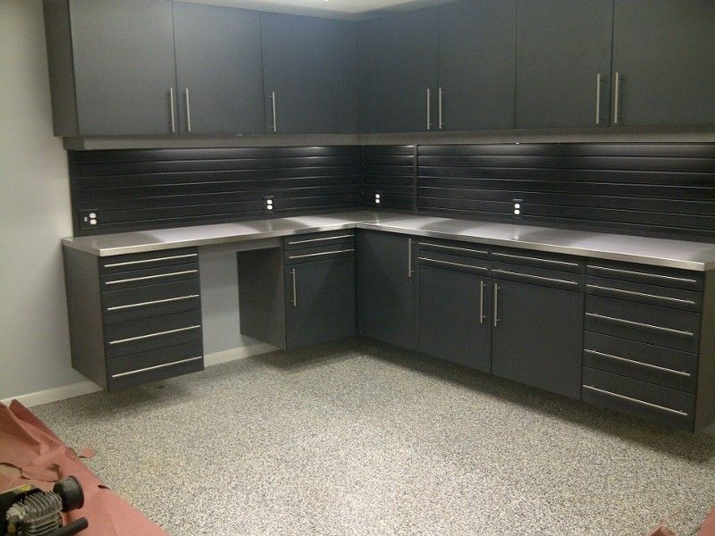 A kitchen with black cabinets and stainless steel counter tops