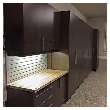 A kitchen with lots of cabinets and a wooden counter top.