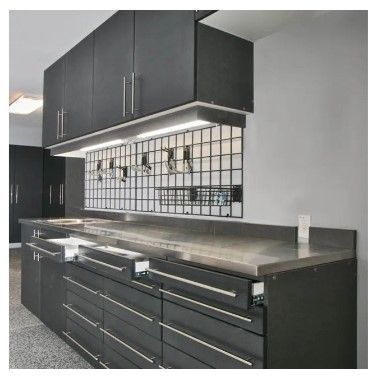 A kitchen with black cabinets and a stainless steel counter top