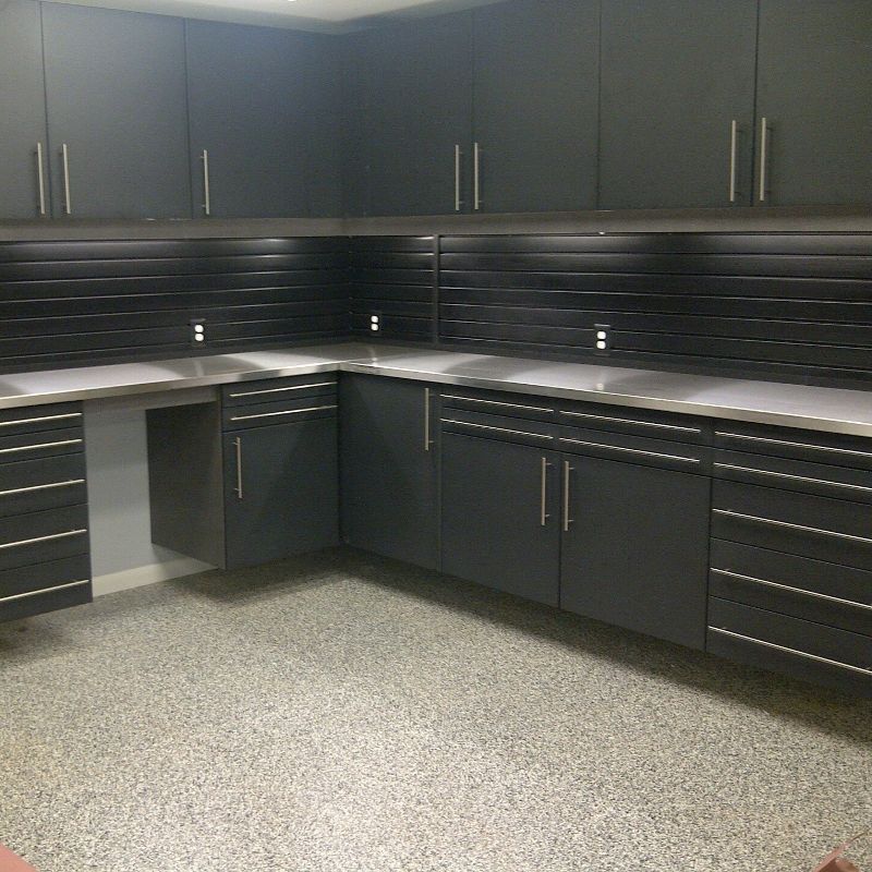 A kitchen with black cabinets and stainless steel counter tops