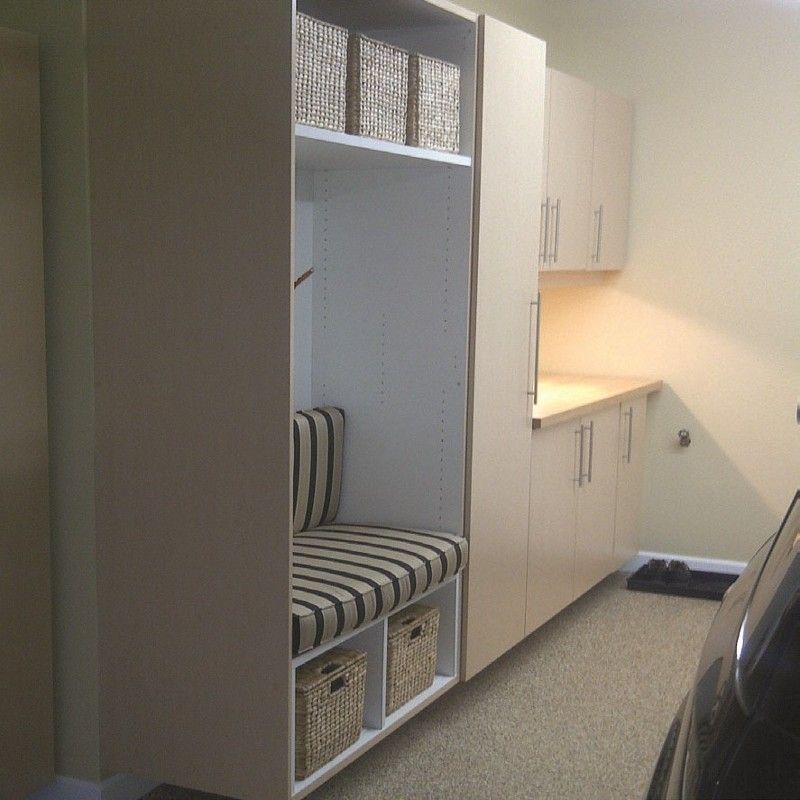 A laundry room with a bench and wicker baskets.