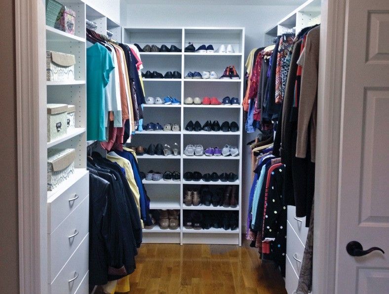 A walk in closet filled with lots of clothes and shoes.