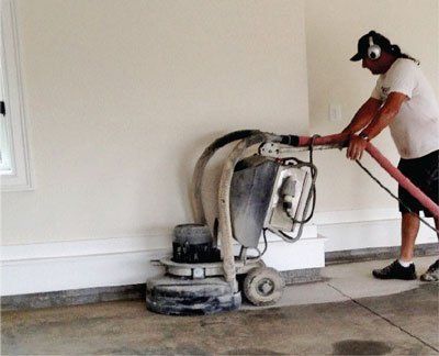 A man wearing headphones is using a machine on a concrete floor